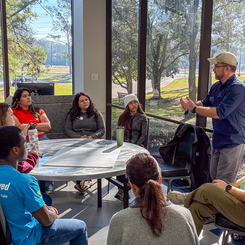 A group of people sitting at a table having a conversation.