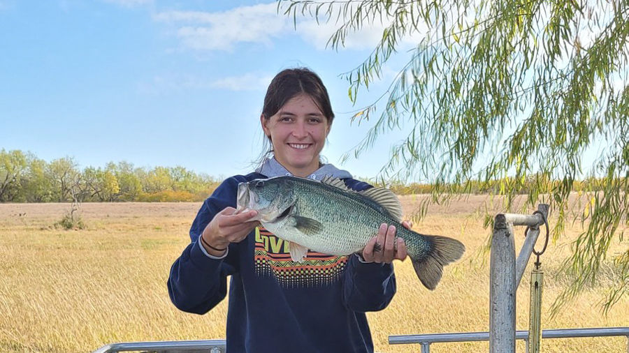 Tenley Housler Tenley is holding up a large fish and smiling at the camera.