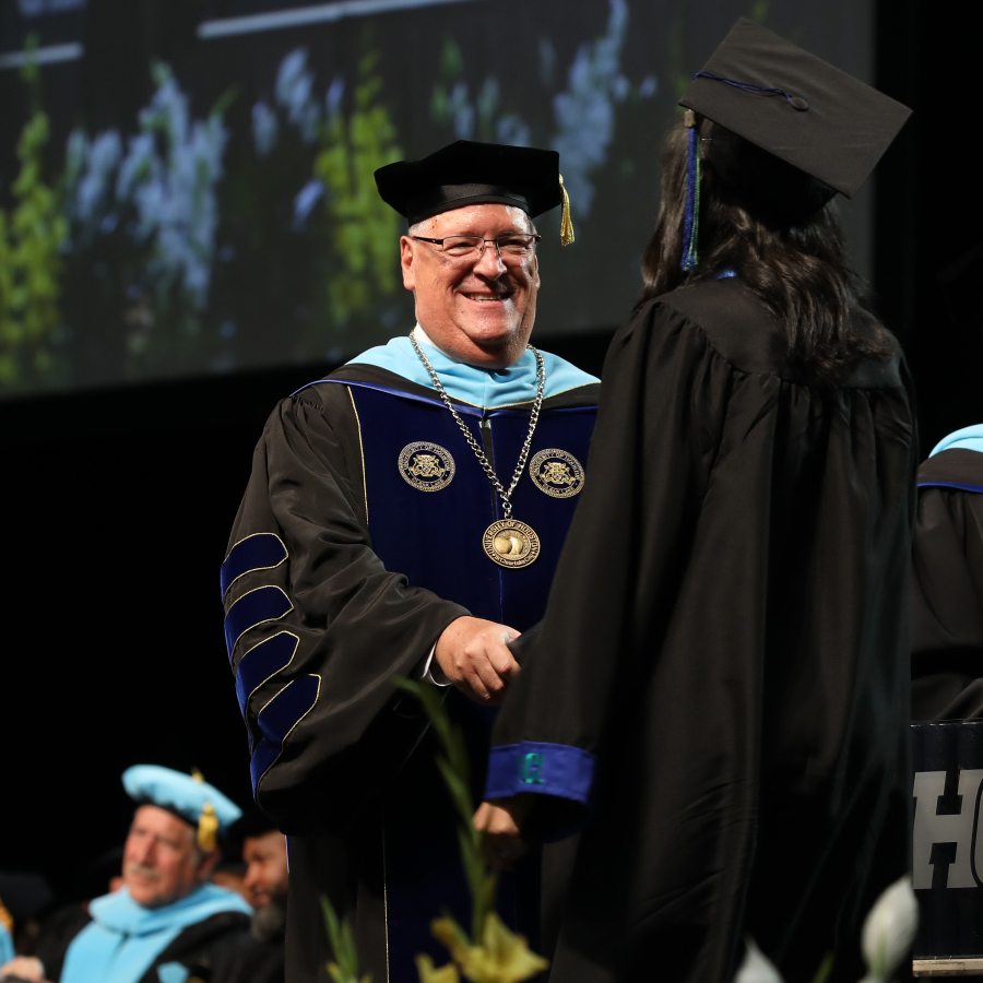 Photo of Dr. Walker on stage at a UHCL Commencement Ceremony