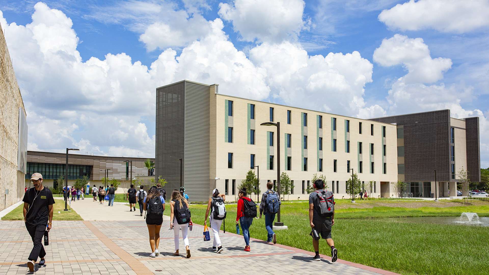 Students walk along a paved campus pathway outside